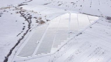 Güneş paneli park, fotovoltaik güç istasyonu kış hava dron görünümü kar kaplı