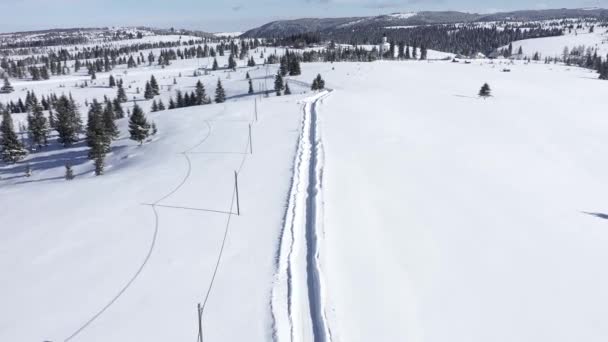 山の雪に覆われた道路の上飛んでいます ドローン撮 — ストック動画