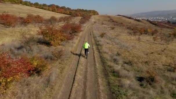 从一架无人机上看到 一辆骑自行车的人在户外骑自行车 从他身后的稳定 活跃的轨道上 — 图库视频影像