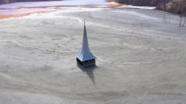 Ekolojik felaket, bir bakır madeninden siyanür ile kontamine bir gölün ortasında su altında bırakılan ve terkedilmiş kilisenin 4k hava drone görünümü. Geayana, Romanya