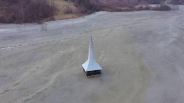 Ekolojik felaket, bir bakır madeninden siyanür ile kontamine bir gölün ortasında su altında bırakılan ve terkedilmiş kilisenin 4k hava drone görünümü. Geayana, Romanya