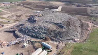 Büyük çöp yığını hava üst drone görünümü, çöp dökümü, atık depolama, ev atıcı site çöp, ekskavatör makinesi bir dağ çöp üzerinde çalışıyor. Tüketim ve kontaminasyon konsepti