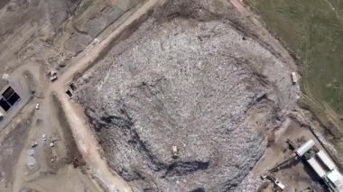 Büyük çöp yığını hava üst drone görünümü, çöp dökümü, atık depolama, ev atıcı site çöp, ekskavatör makinesi bir dağ çöp üzerinde çalışıyor. Tüketim ve kontaminasyon konsepti
