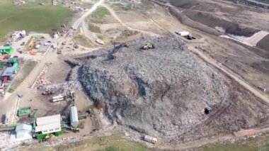Büyük çöp yığını hava üst drone görünümü, çöp dökümü, atık depolama, ev atıcı site çöp, ekskavatör makinesi bir dağ çöp üzerinde çalışıyor. Tüketim ve kontaminasyon konsepti
