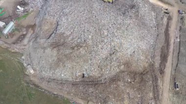 Büyük çöp yığını hava üst drone görünümü, çöp dökümü, atık depolama, ev atıcı site çöp, ekskavatör makinesi bir dağ çöp üzerinde çalışıyor. Tüketim ve kontaminasyon konsepti