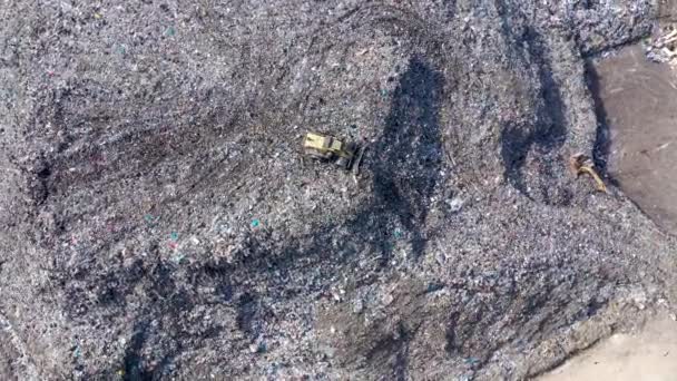 Vue aérienne du drone supérieur d'une grande poubelle, d'une décharge, d'une décharge, de déchets provenant d'un dépotoir domestique, une excavatrice travaille sur une poubelle de montagne. Concept de consommation et de contamination 