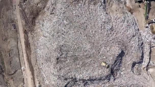 Vue aérienne du drone supérieur d'une grande poubelle, d'une décharge, d'une décharge, de déchets provenant d'un dépotoir domestique, une excavatrice travaille sur une poubelle de montagne. Concept de consommation et de contamination 