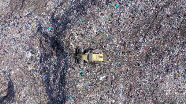 Aerial top drone view of large garbage pile, trash dump, landfill, waste from household dumping site, excavator machine is working on a mountain garbage. Consumerism and contamination concept