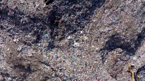大きなごみパイルの空中トップドローンビュー ゴミ捨て場 埋立地 家庭用投棄現場からの廃棄物 ショベルマシンは 山のごみに取り組んでいます 消費主義と汚染の概念 — ストック動画