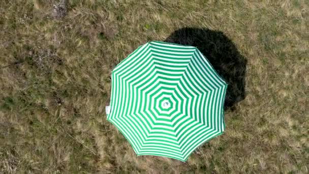 空中4K 无人机在草地上看到一把绿色的太阳伞 — 图库视频影像