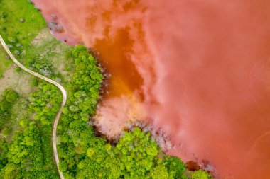 Kırmızı atık su ve yeşil ormanın havadan görünümü