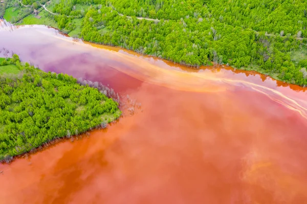 붉은 폐수와 녹색 숲의 공중 보기 — 스톡 사진