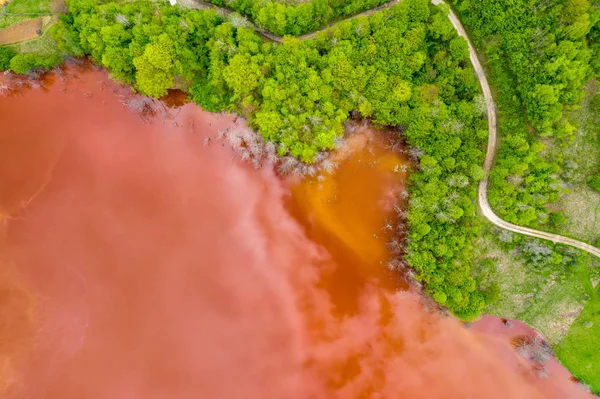 Vue aérienne des eaux usées rouges et de la forêt verte — Photo