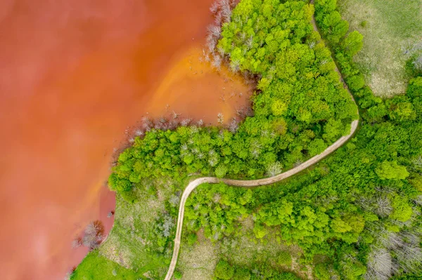 Letecký pohled na červenou odpadní vodu a zelený Les — Stock fotografie