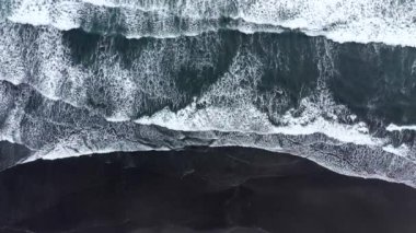 Siyah volkanik kum kıyıya acele dalgalar hava drone görünümü. Atlantic Ocean, Izlanda