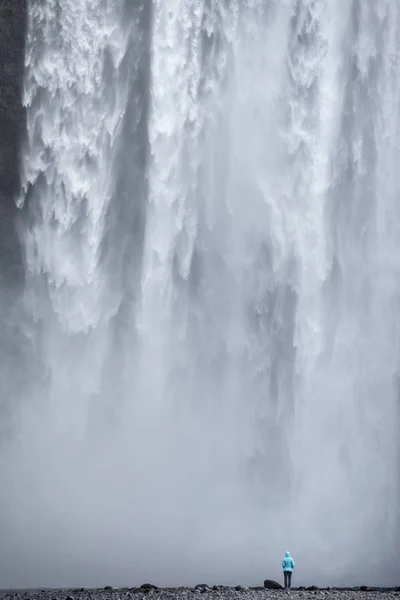 Kvinna som beundrar Skogafoss vattenfall på Island — Stockfoto