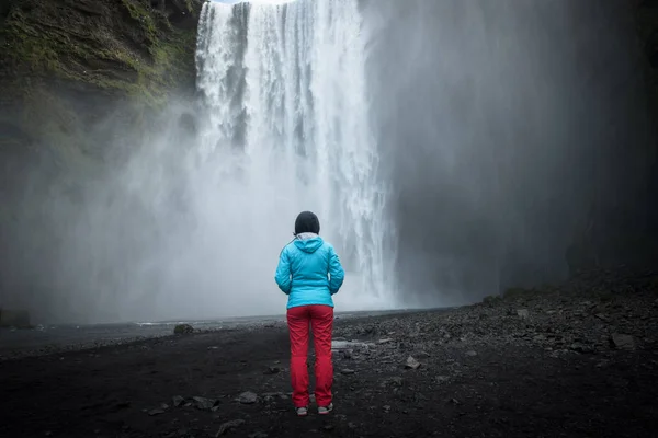 Mulher admirando a cachoeira Skogafoss na Islândia — Fotografia de Stock