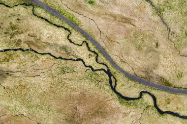 İzlanda'da yeşil alanda sarma küçük nehir, dere havadan görünümü