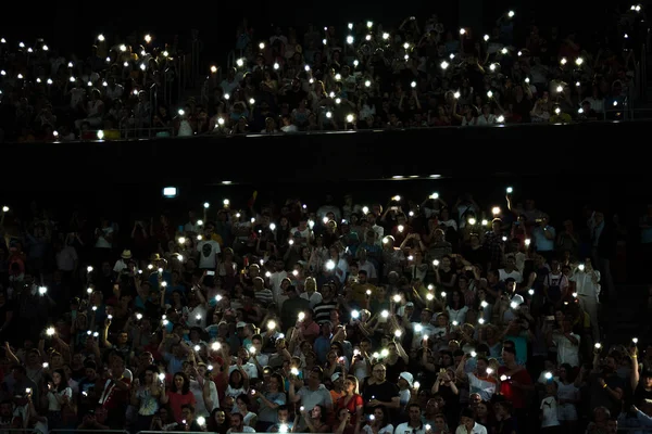 Cep telefonu ışıkları ile el sallayan insan kalabalığı — Stok fotoğraf