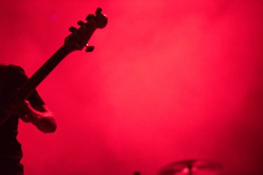 Bas gitar çalan bir müzisyenin silueti
