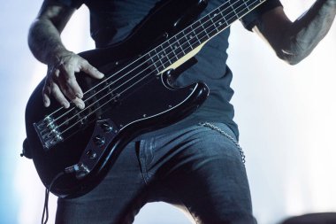 Bas gitar çalan bir müzisyenin detayı
