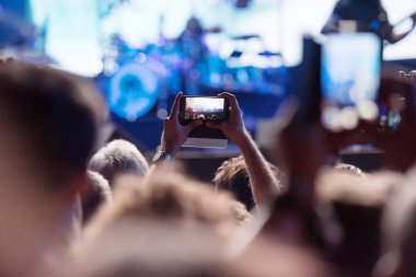 Bir konser sırasında akıllı telefonlar ile fotoğraf çeken insanlar 