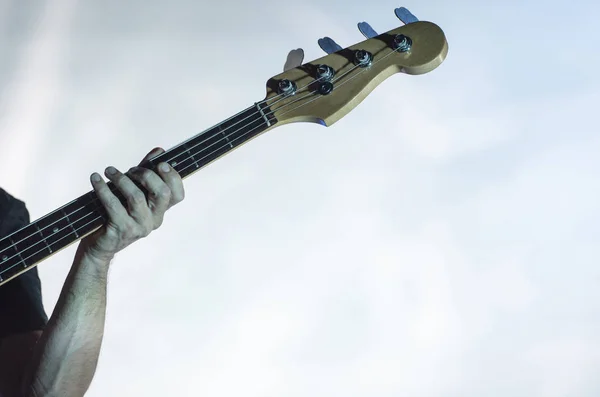 Detail of a musician playing on a bass guitar — Stock Photo, Image