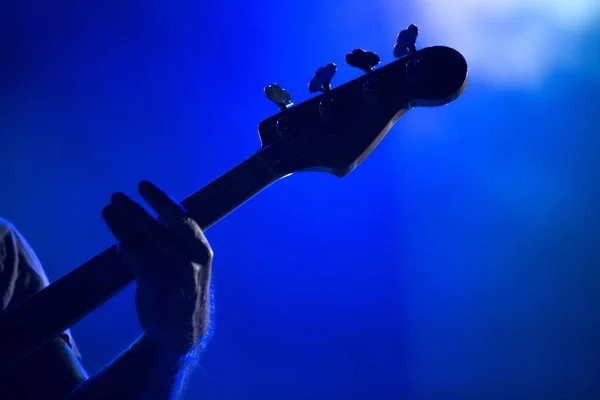 Silhueta de um músico tocando em uma guitarra baixo Imagens De Bancos De Imagens Sem Royalties