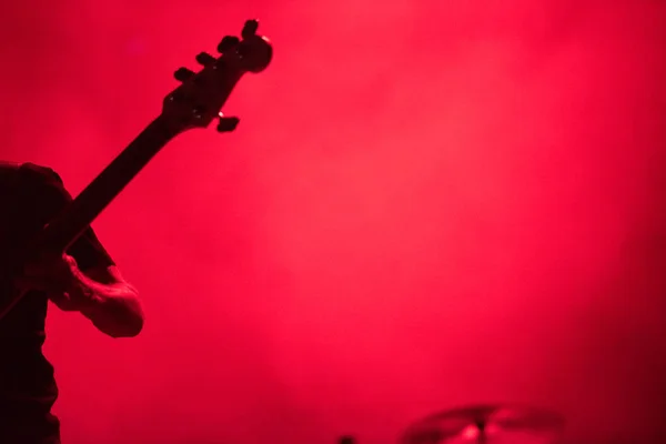 Silhouette eines Musikers, der auf einer Bassgitarre spielt Stockbild