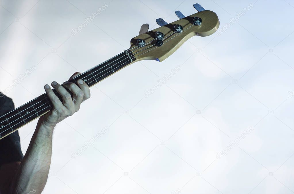 Detail of a musician playing on a bass guitar
