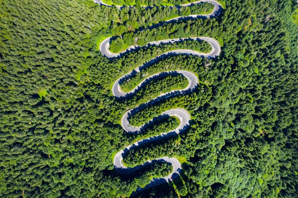 Vista aérea superior de uma estrada sinuosa na floresta verde — Fotografia de Stock