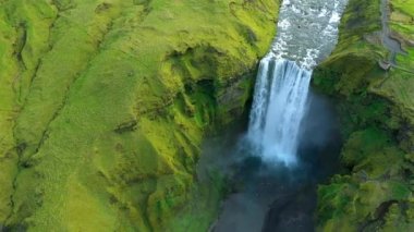  İzlanda 'daki Skogafoss şelalesinin üzerinde uçan 4k hava aracı görüntüsü. Canlı yeşil İzlanda manzarası 