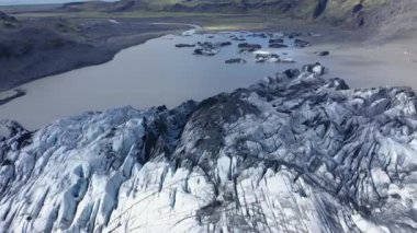 İzlanda 'daki eriyen Solheimajokull buzulunun 4k hava aracı yüksek açılı görüntüsü. İklim değişikliği, eriyen buzullar, küresel ısınma kavramı