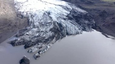 İzlanda 'daki eriyen Solheimajokull buzulunun 4k hava aracı yüksek açılı görüntüsü. İklim değişikliği, eriyen buzullar, küresel ısınma kavramı