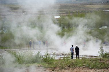 STROKKUR GEYSER, ICELAND - 20 Mayıs 2019: İzlanda Altın Çemberinde Strokkur gayzerinin patlamasını ziyaret eden ve bekleyen turistler