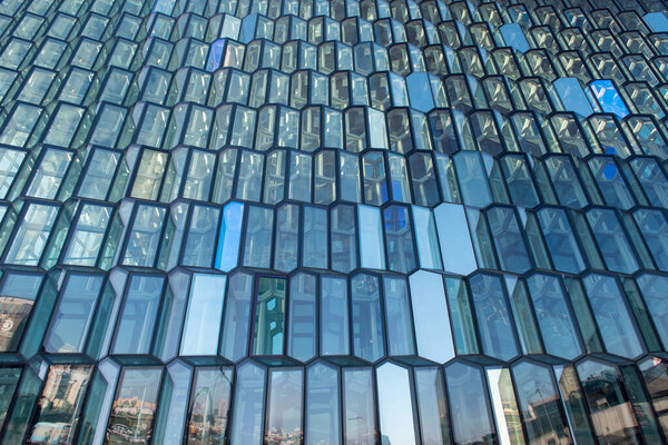 REYKJAVIK, ICELAND - MAY 24, 2019: The Harpa Concert Hall building features a distinctive colored glass facade inspired by the basalt landscape of Iceland