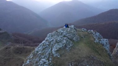  Dağ yamacında dinlenen bir çiftin üzerinde uçmak. Havadan 
