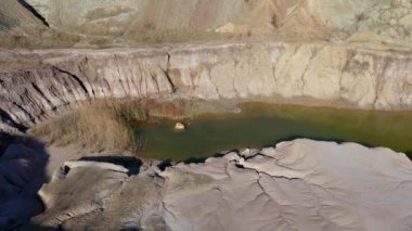 Terk edilmiş ve sular altında kalmış çukur alçıtaşı madeni, taş ocağı, kirli gölet manzarası.