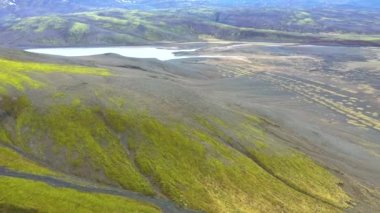 Dev bir volkanik plato üzerinde uçan lav akıntısı İzlanda 'da canlı yeşil yosunlarla birlikte.