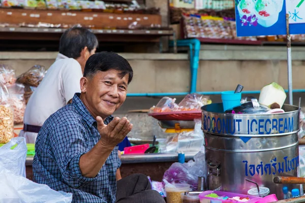 Damnoen Saduak, Thailand - August 29, 2018: Man selling coconut ice cream from a boat in Damnoen Saduak Floating Market, Ratchaburi, Thailand