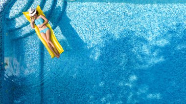 Güzel genç kız rahatlatıcı yüzme havuzunda şişme yatak üzerinde yüzüyor ve aile tatil tropikal tatil, hava uçak görünümü yukarıdan su eğlence var