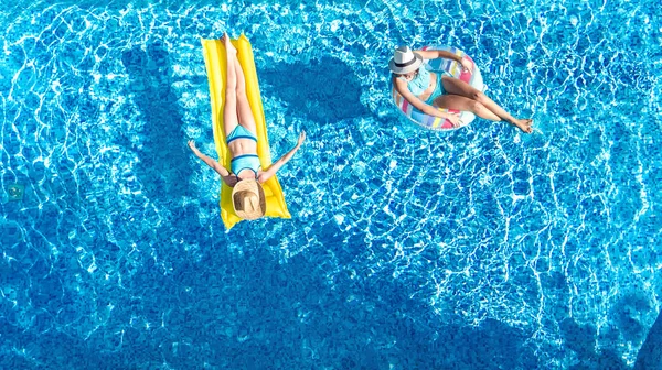 空中ドローン上からスイミング プールで子供観 子供泳いでインフレータブル リング ドーナツとマットレスの幸せな女の子で楽しく水の家族休暇ホリデイ リゾートの — ストック写真