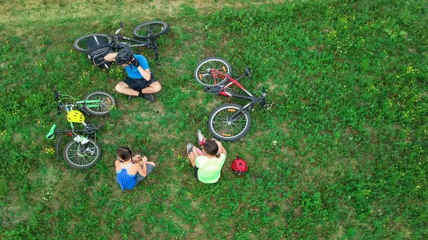 自行车家庭自行车户外空中无人机视图从上面 快乐的积极的父母与孩子有乐趣和放松在草 家庭体育和健身在周末 — 图库照片