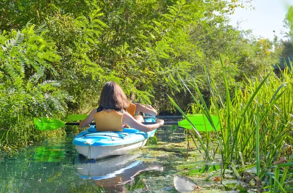 Family kayaking, mother and daughter paddling in kayak on river canoe tour having fun, active autumn weekend and vacation with children, fitness concept