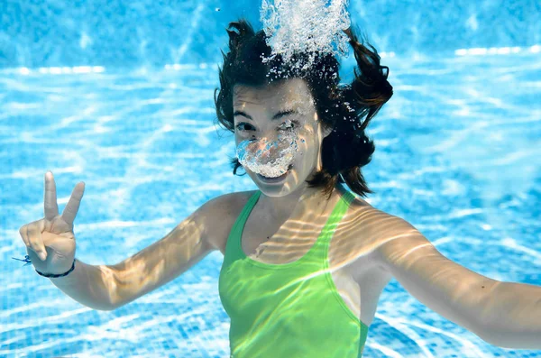 女孩游泳在游泳池水下 愉快活跃少年潜水并且有乐趣在水之下 孩子健身和体育在家庭假日在度假胜地 — 图库照片