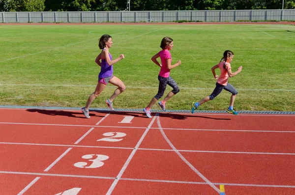 Family sport and fitness, happy mother and kids running on stadium track outdoors, children healthy active  lifestyle concept