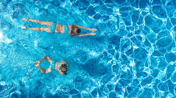 Kızlar yüzme havuzu su yukarıdan, etkin çocuklar yüzmek, çocuklar hava dron görünümü var eğlenceli tropikal Ailecek tatile, holiday resort konsepti