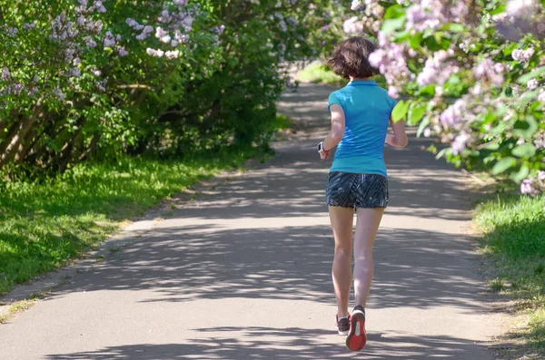 Corridore Donna Jogging Nel Parco Primaverile Con Fiori Lilla Corsa — Foto Stock