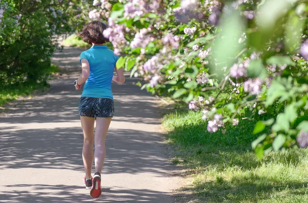Žena Běžec Běhání Parku Jaře Fialovými Květy Ranní Běh Venku — Stock fotografie