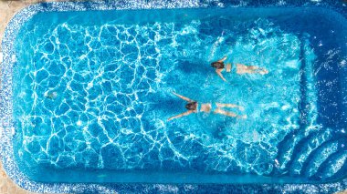 Çocuk yüzme havuzu su hava dron görünümünde yukarıdan aktif kızlar, yüzmek, çocuklar eğlenin tropikal Ailecek tatile, holiday resort konsepti